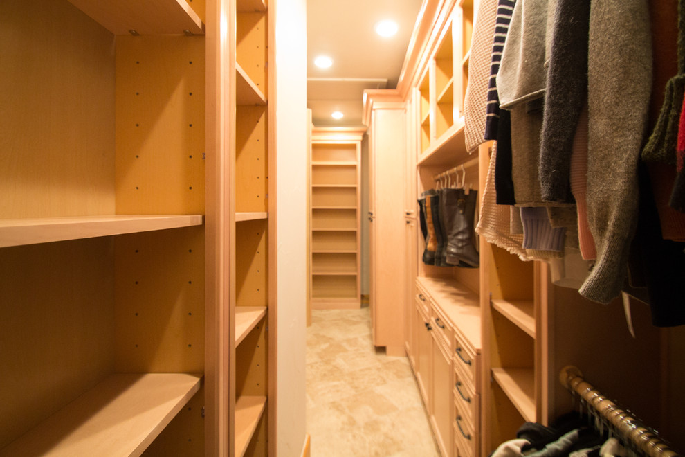 Photo of a large classic gender neutral walk-in wardrobe in Denver with raised-panel cabinets, light wood cabinets, travertine flooring and beige floors.