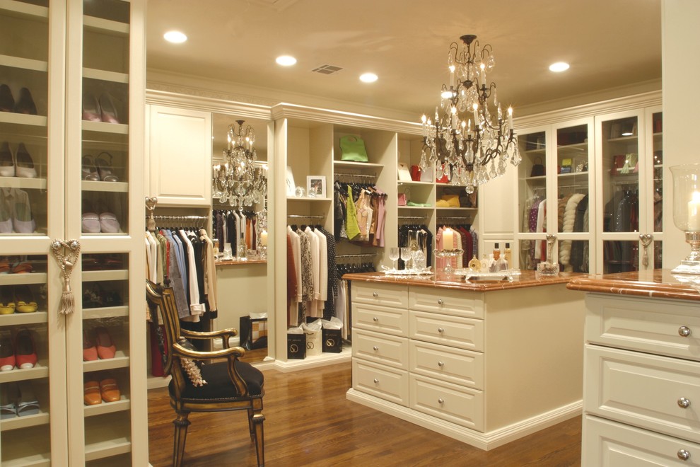 Photo of an expansive traditional walk-in wardrobe for women in Orange County with raised-panel cabinets and white cabinets.