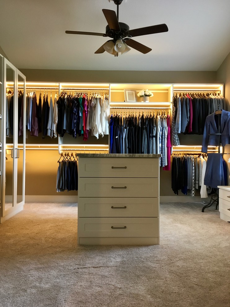 Medium sized contemporary walk-in wardrobe for women in Chicago with shaker cabinets, beige cabinets, carpet and beige floors.