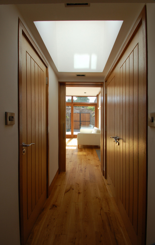 Ejemplo de armario vestidor unisex contemporáneo de tamaño medio con armarios estilo shaker, puertas de armario de madera oscura y suelo de madera en tonos medios