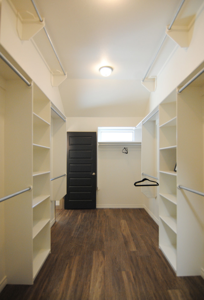 Large trendy gender-neutral vinyl floor walk-in closet photo in Austin with white cabinets
