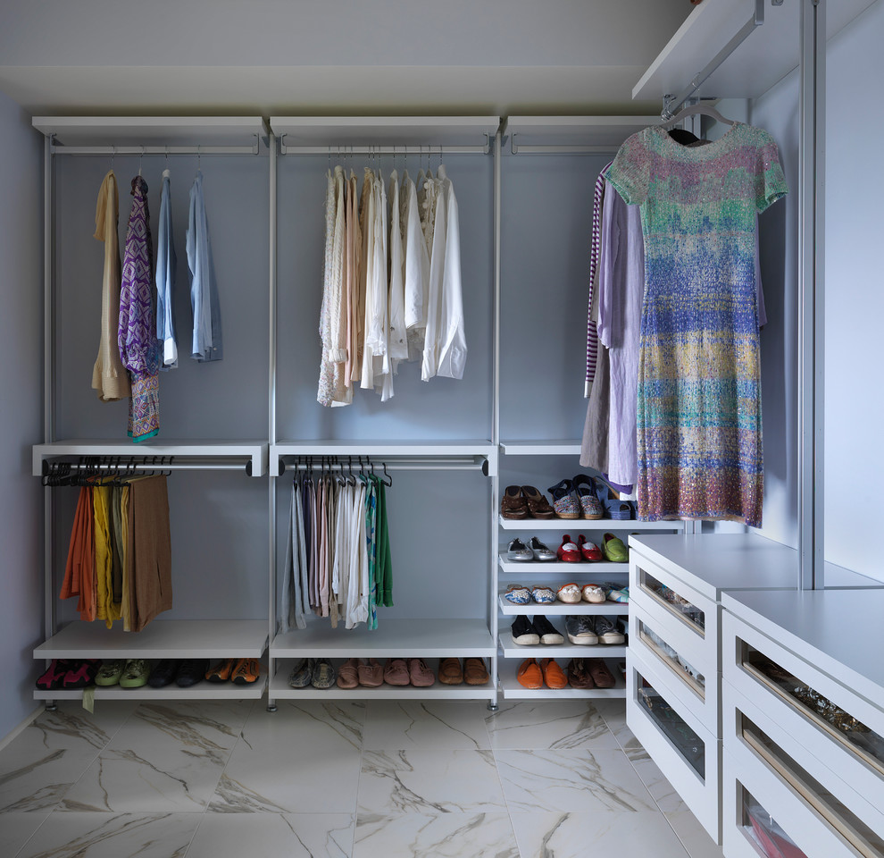 На фото: гардеробная комната среднего размера, унисекс в современном стиле с плоскими фасадами, белыми фасадами и мраморным полом с
