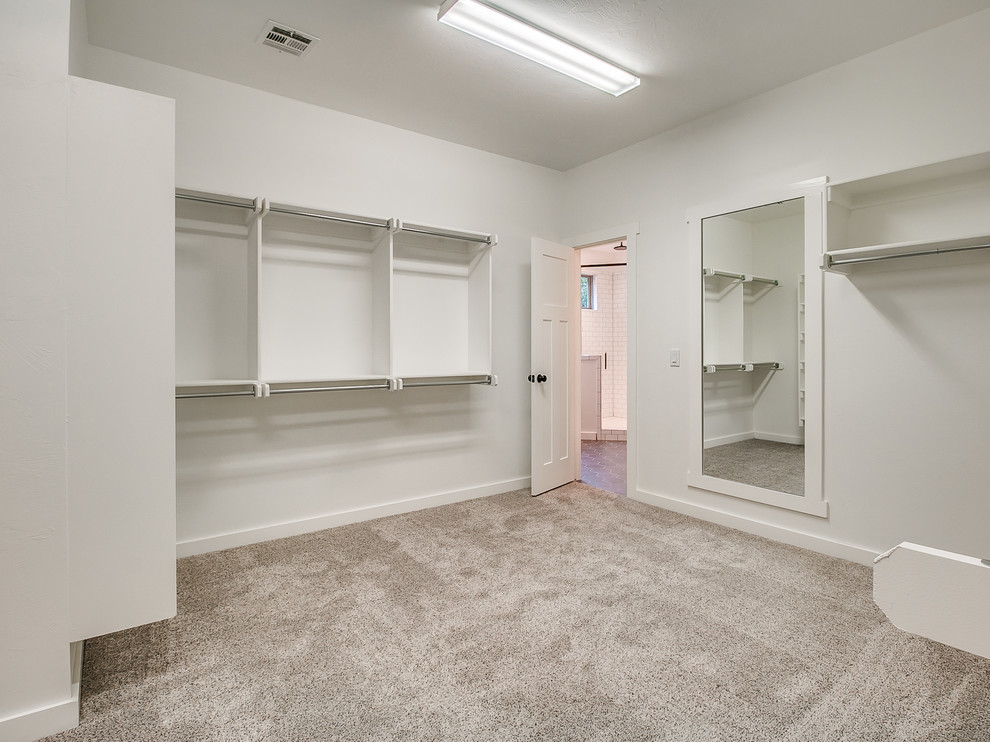 Photo of a large country gender neutral walk-in wardrobe in Oklahoma City with carpet and grey floors.