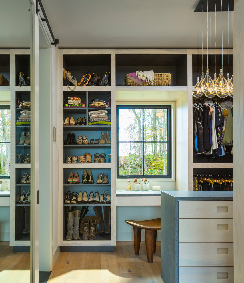 Inspiration for a medium sized farmhouse gender neutral walk-in wardrobe in Burlington with flat-panel cabinets, light wood cabinets, medium hardwood flooring, brown floors and feature lighting.