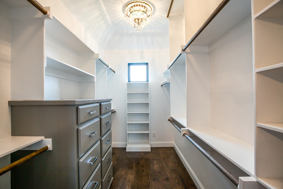Inspiration for a large cottage gender-neutral dark wood floor and brown floor walk-in closet remodel in Dallas with raised-panel cabinets and blue cabinets