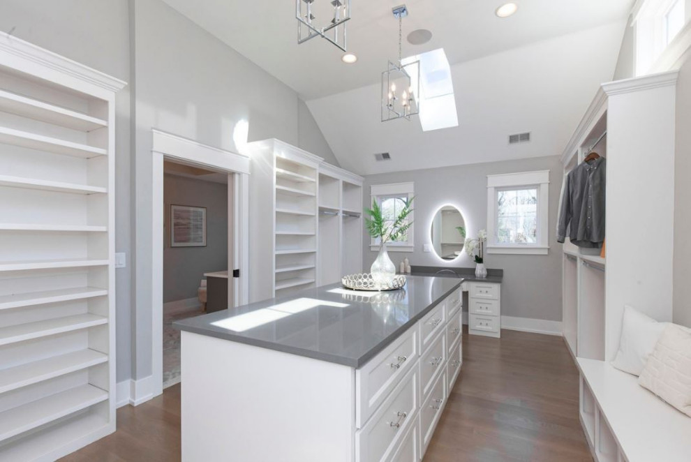 Inspiration for a large country gender neutral walk-in wardrobe in Chicago with open cabinets, white cabinets, light hardwood flooring, brown floors and a drop ceiling.