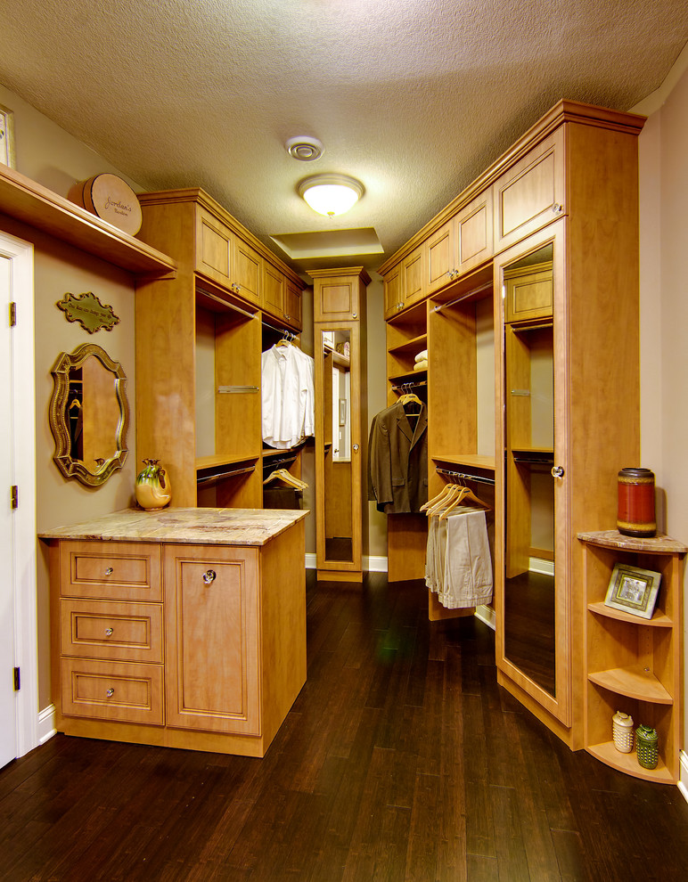 Inspiration för stora klassiska walk-in-closets, med skåp i mellenmörkt trä, luckor med infälld panel, mörkt trägolv och brunt golv
