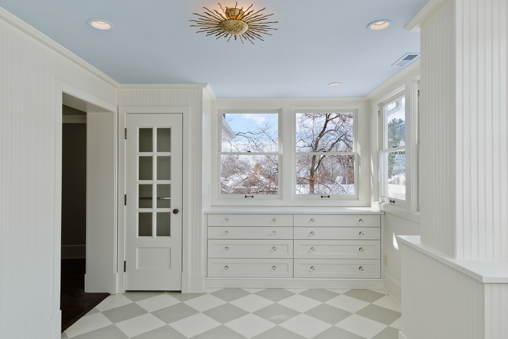 Example of a classic ceramic tile walk-in closet design in Salt Lake City with white cabinets