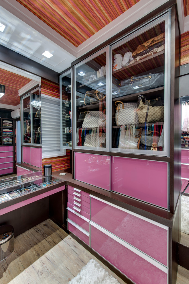 Идея дизайна: гардеробная комната в современном стиле с стеклянными фасадами для женщин