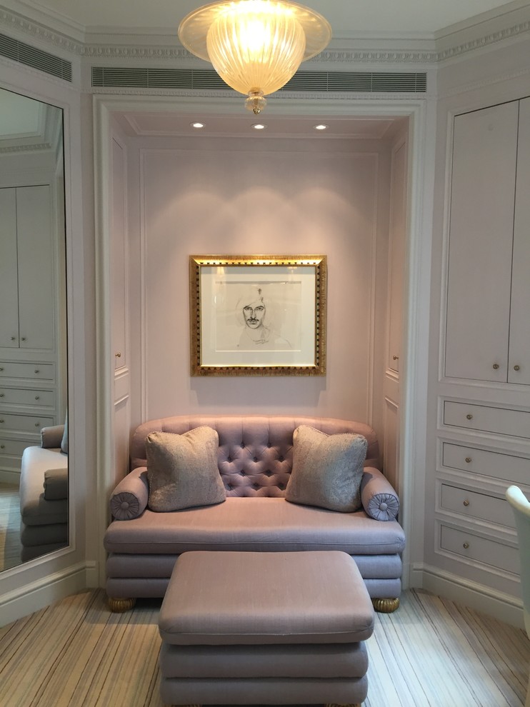 Inspiration for a mid-sized timeless women's carpeted dressing room remodel in New York with recessed-panel cabinets and white cabinets