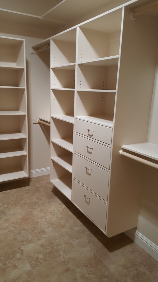 Photo of a large contemporary gender neutral walk-in wardrobe in Sacramento with flat-panel cabinets, white cabinets and travertine flooring.