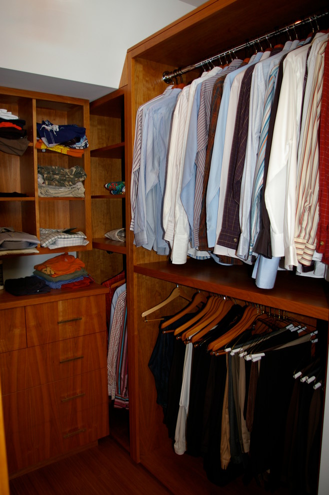 Ejemplo de armario vestidor unisex contemporáneo de tamaño medio con armarios con paneles lisos, puertas de armario de madera oscura y suelo de madera en tonos medios