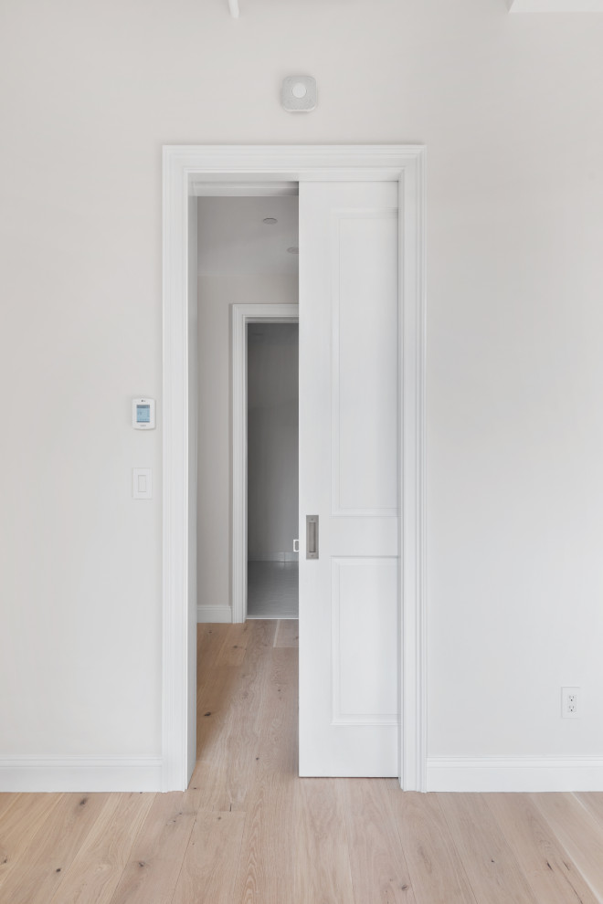 Пример оригинального дизайна: гардеробная комната среднего размера, унисекс в стиле неоклассика (современная классика) с светлым паркетным полом и бежевым полом
