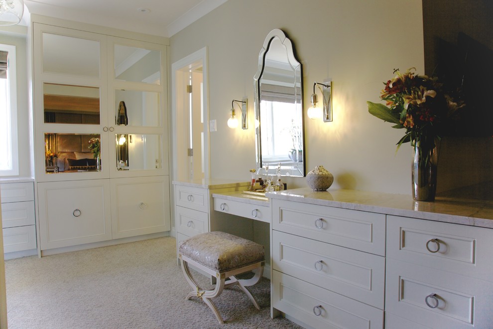 Cette image montre un grand dressing traditionnel neutre avec des portes de placard blanches, moquette et un placard avec porte à panneau encastré.