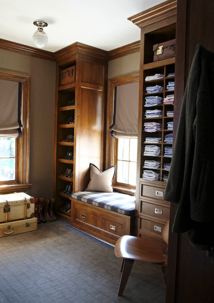 Exemple d'un dressing room chic en bois brun pour un homme avec un placard avec porte à panneau encastré, moquette et un sol bleu.
