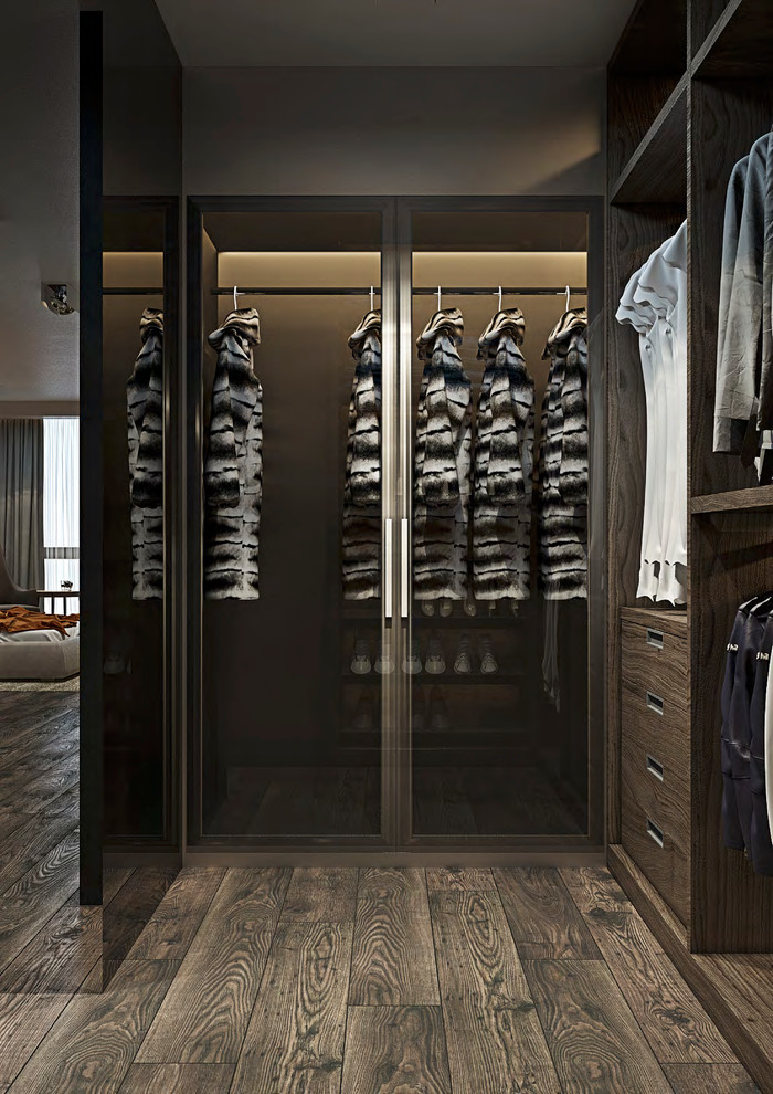 This is an example of a large modern gender neutral walk-in wardrobe with flat-panel cabinets, dark wood cabinets, dark hardwood flooring and brown floors.