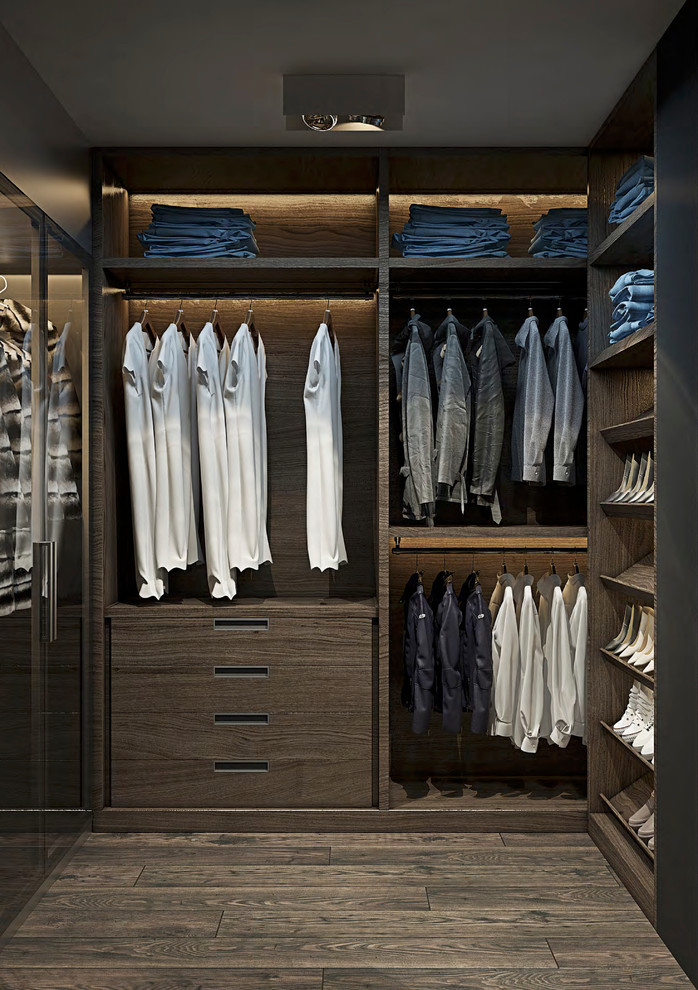 Ejemplo de armario vestidor unisex minimalista grande con armarios con paneles lisos, puertas de armario de madera en tonos medios, suelo de madera oscura y suelo marrón