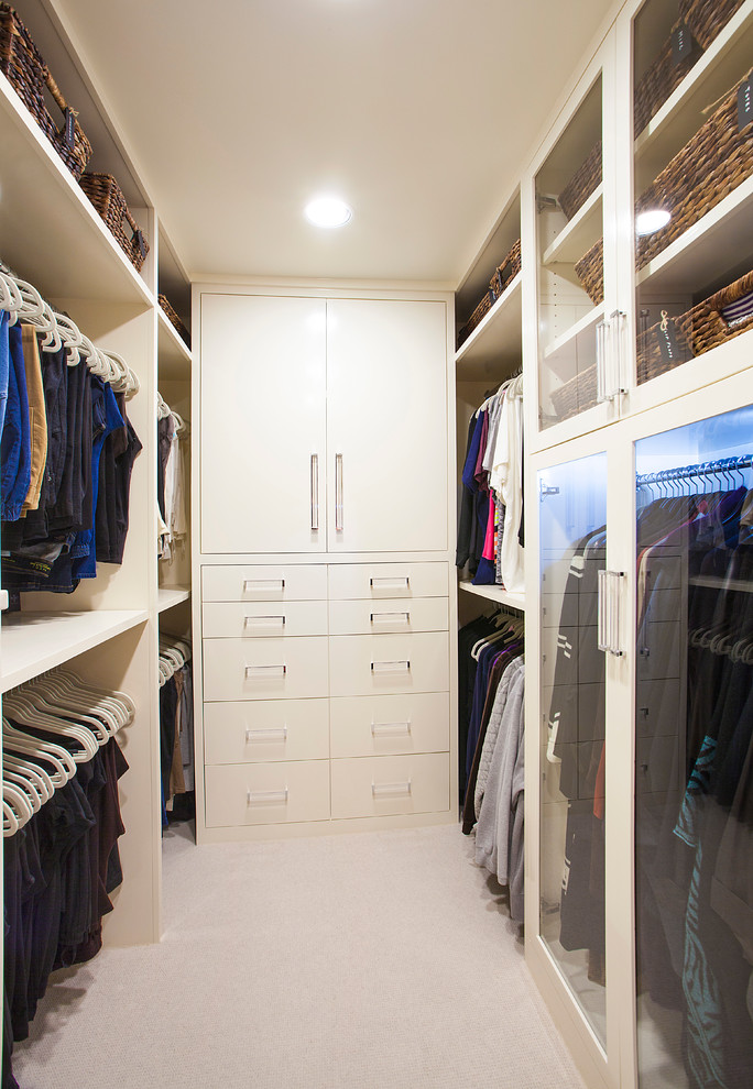 На фото: гардеробная комната среднего размера в стиле неоклассика (современная классика) с плоскими фасадами, белыми фасадами и ковровым покрытием для женщин с