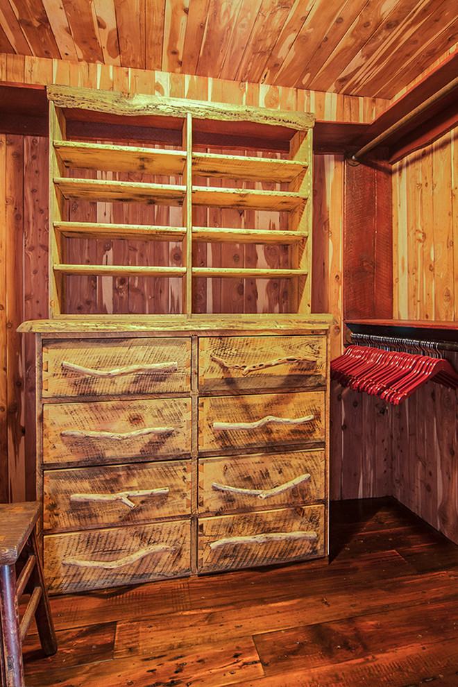 Rustik inredning av ett mellanstort walk-in-closet för könsneutrala, med släta luckor, skåp i slitet trä och mörkt trägolv
