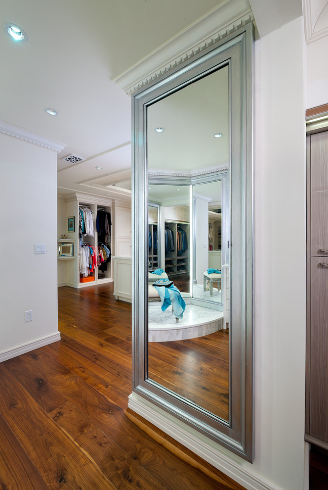 Example of a huge classic women's light wood floor dressing room design in Other with beaded inset cabinets and white cabinets