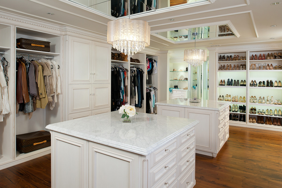 Foto de vestidor de mujer clásico extra grande con armarios con rebordes decorativos, puertas de armario blancas y suelo de madera clara