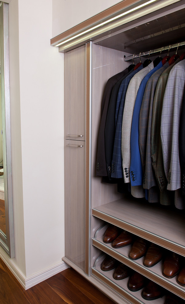 Inspiration pour un très grand dressing room design en bois clair pour un homme avec un placard sans porte et parquet clair.