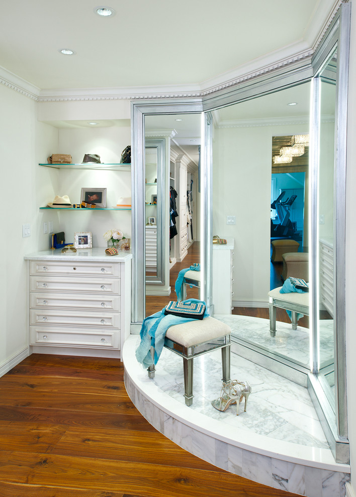 Geräumiges Klassisches Ankleidezimmer mit Ankleidebereich, weißen Schränken, braunem Holzboden und braunem Boden in Sonstige