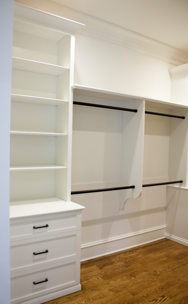 This is an example of a large classic gender neutral walk-in wardrobe in Other with shaker cabinets, white cabinets, medium hardwood flooring and brown floors.
