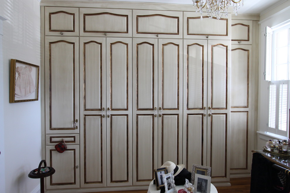 Idées déco pour un dressing room victorien en bois vieilli de taille moyenne et neutre avec un placard avec porte à panneau surélevé et parquet clair.