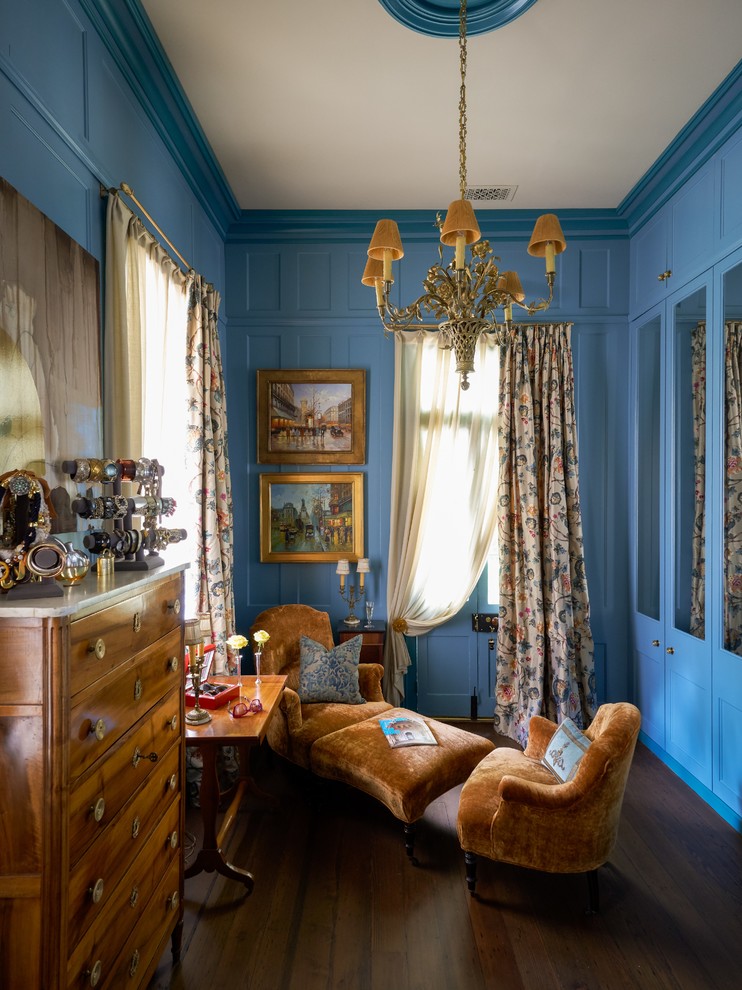 Aménagement d'un dressing et rangement classique avec un placard avec porte à panneau encastré, des portes de placard bleues, parquet foncé et un sol marron.