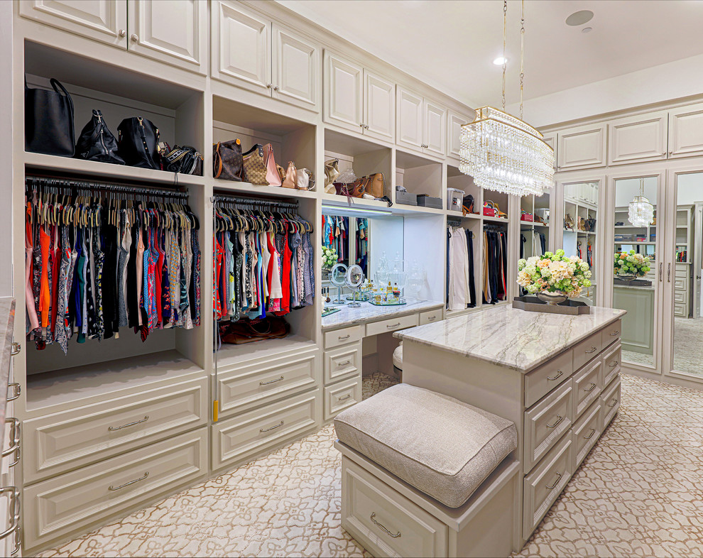 Ejemplo de armario vestidor de mujer tradicional grande con armarios con paneles empotrados, puertas de armario beige, moqueta y suelo beige