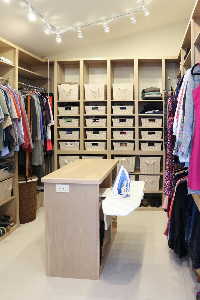 Modelo de armario vestidor unisex y abovedado tradicional renovado de tamaño medio con armarios con paneles lisos, suelo de baldosas de cerámica, puertas de armario beige y suelo beige