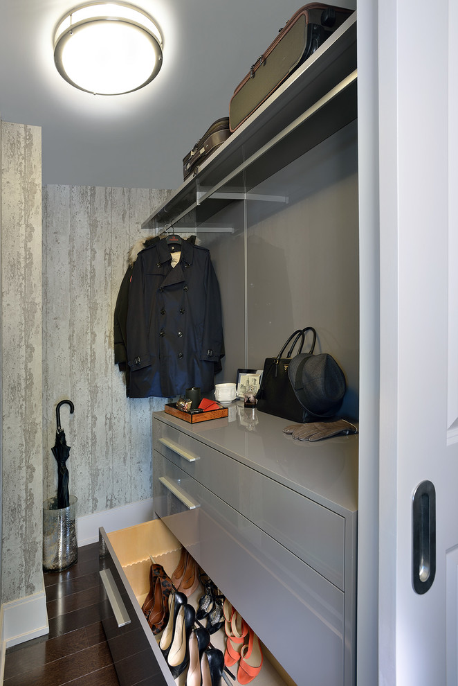 Photo of a small classic gender neutral walk-in wardrobe in Toronto with flat-panel cabinets, grey cabinets and dark hardwood flooring.