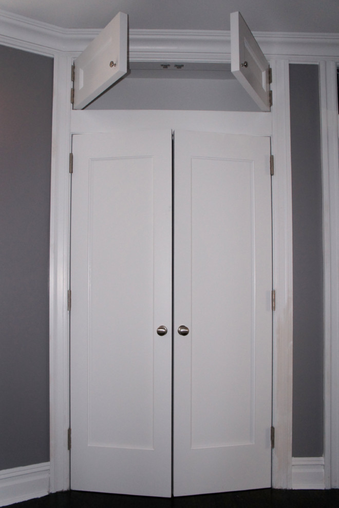 Diseño de armario unisex clásico de tamaño medio con armarios estilo shaker, puertas de armario blancas y suelo de madera oscura