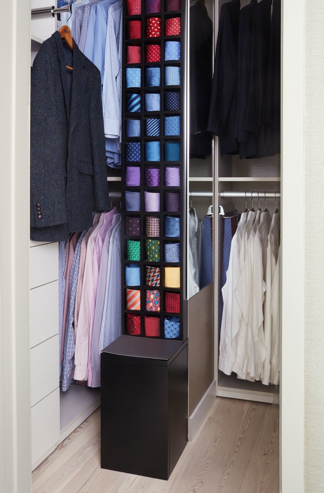 Photo of a contemporary wardrobe for men in New York with open cabinets, light hardwood flooring and beige floors.