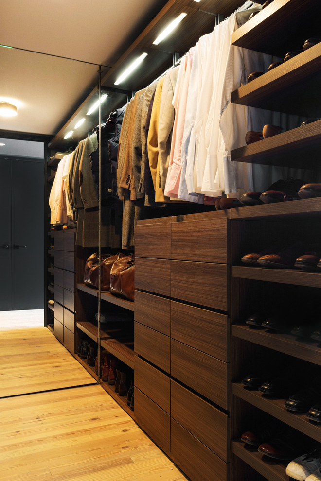 Imagen de armario vestidor de hombre contemporáneo de tamaño medio con armarios con paneles lisos, puertas de armario de madera en tonos medios, suelo de madera clara y suelo beige