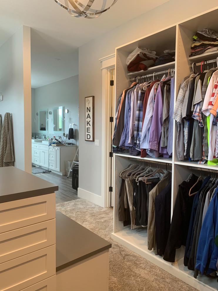 This is an example of a large country gender neutral walk-in wardrobe in Other with shaker cabinets, white cabinets, carpet and grey floors.