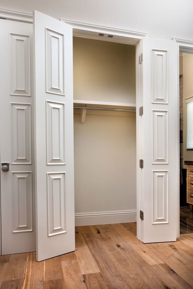 Idee per un armadio o armadio a muro unisex tradizionale con ante bianche e pavimento in legno massello medio