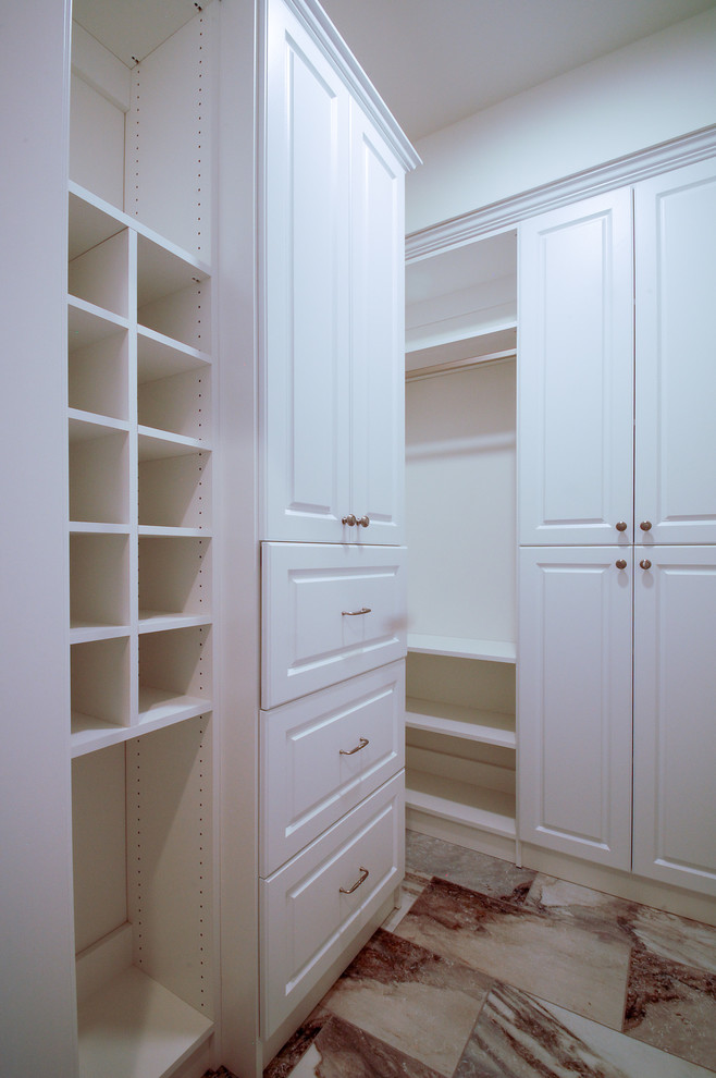 Inredning av ett klassiskt mellanstort walk-in-closet för könsneutrala, med luckor med upphöjd panel, vita skåp och marmorgolv