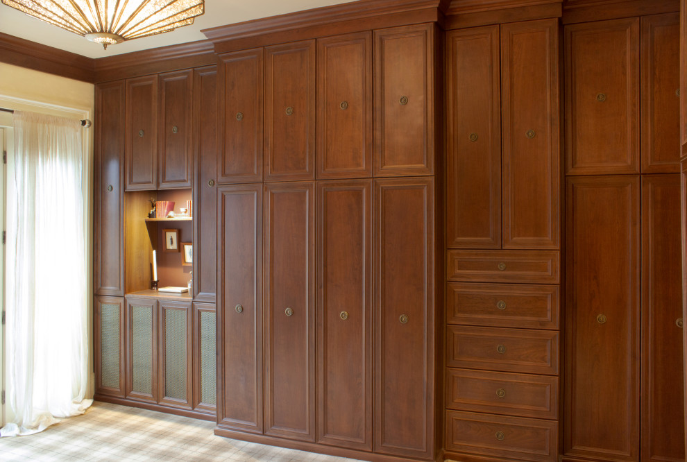 Réalisation d'un dressing room tradition en bois brun pour un homme avec un placard avec porte à panneau encastré, moquette et un sol multicolore.
