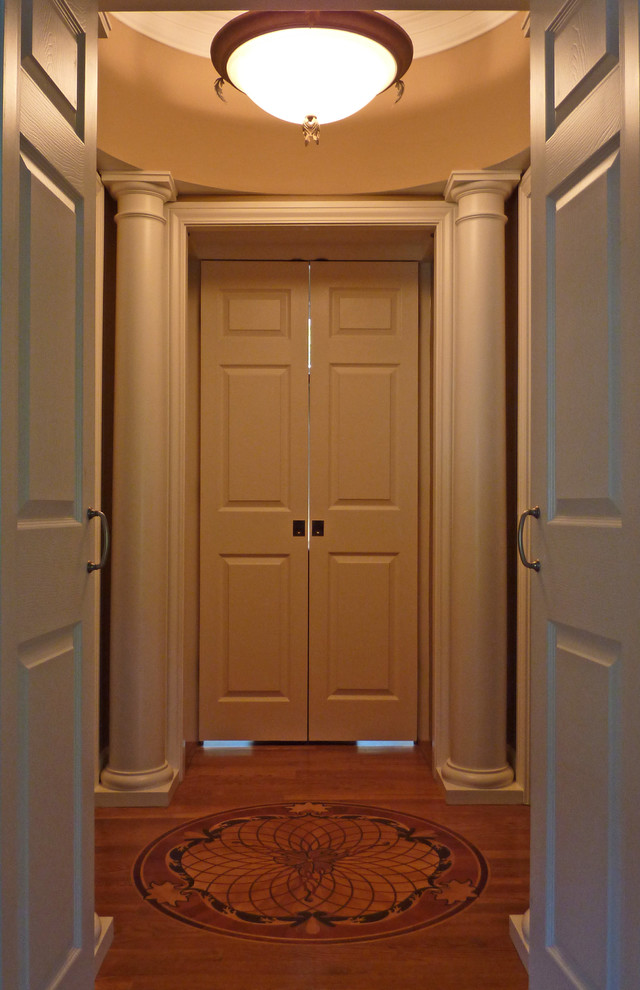 Foto de armario vestidor unisex tradicional con suelo de madera en tonos medios