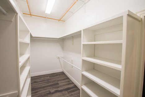 Foto de armario vestidor unisex clásico renovado de tamaño medio con armarios abiertos, puertas de armario blancas y suelo de madera en tonos medios