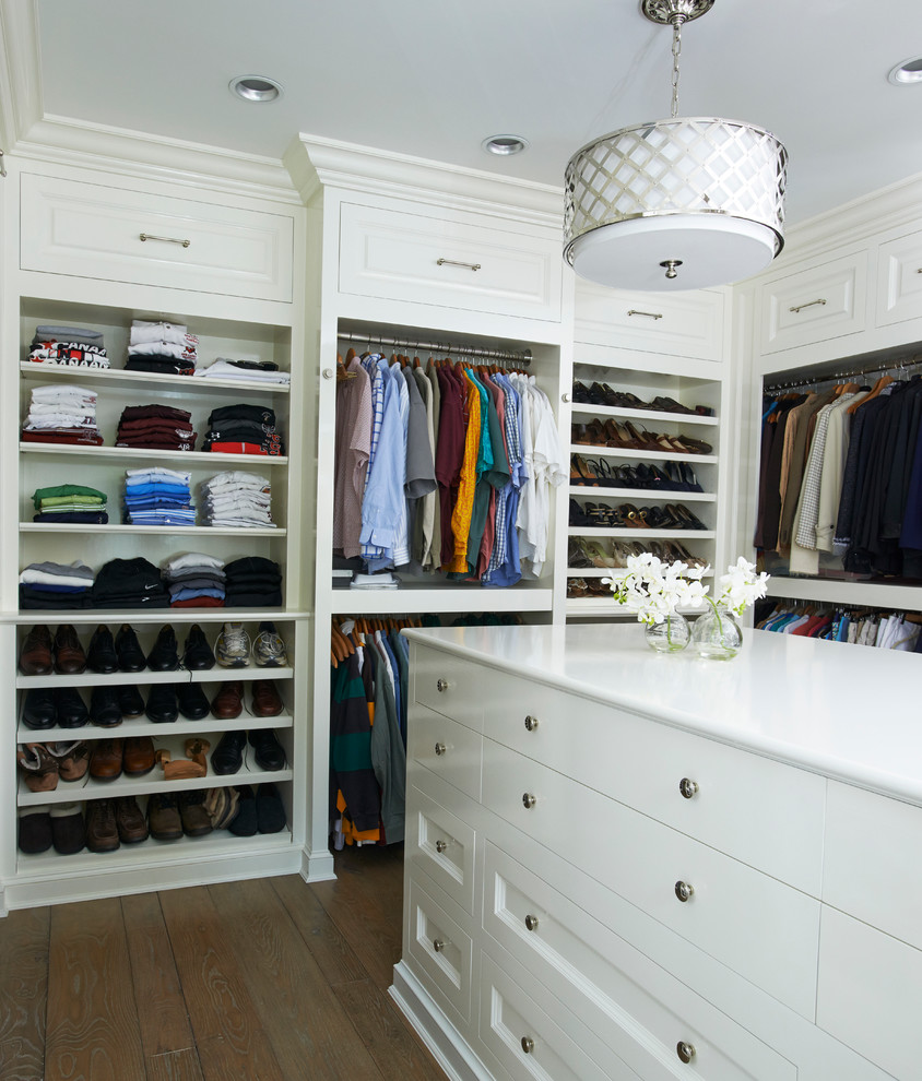 Large elegant gender-neutral dark wood floor and brown floor walk-in closet photo in New York with white cabinets and flat-panel cabinets