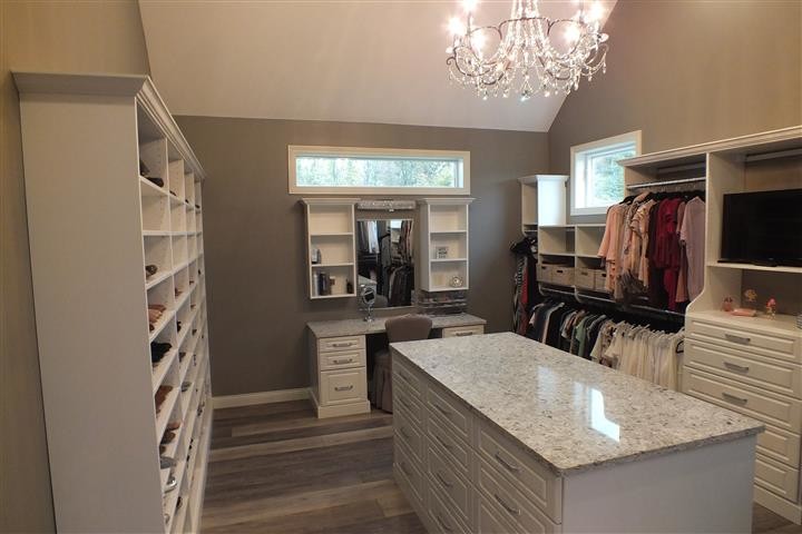 Design ideas for an expansive contemporary gender neutral walk-in wardrobe in Cleveland with raised-panel cabinets, white cabinets, vinyl flooring and multi-coloured floors.