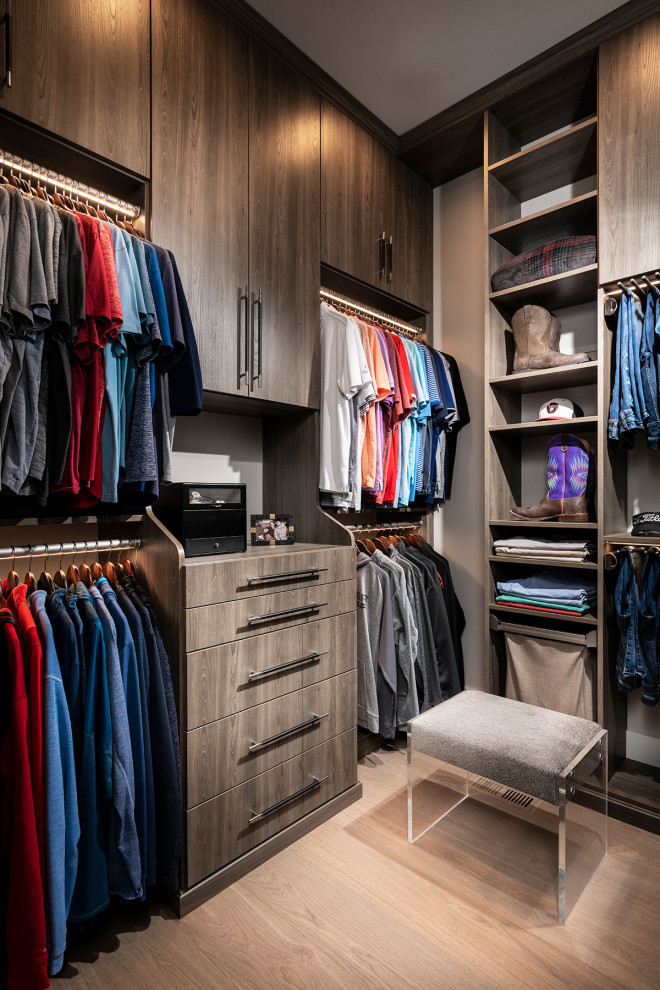 Imagen de armario vestidor de hombre minimalista de tamaño medio con armarios con paneles lisos, puertas de armario de madera oscura, suelo de madera clara y suelo marrón
