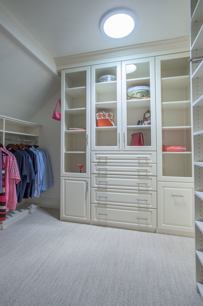 Photo of a classic gender neutral wardrobe in Denver with raised-panel cabinets, white cabinets, carpet and beige floors.