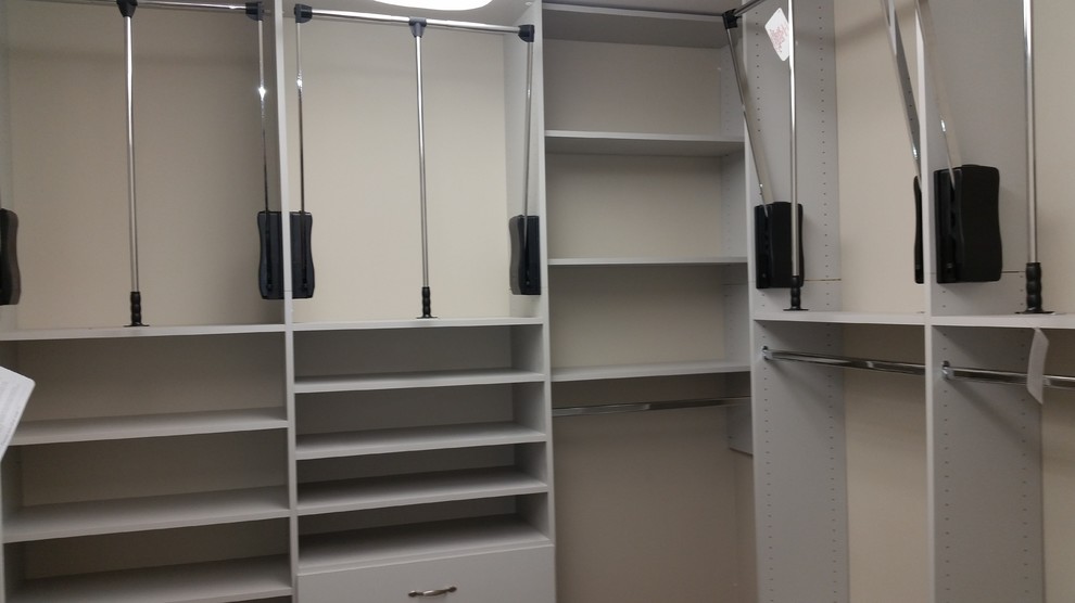Ejemplo de armario vestidor unisex contemporáneo de tamaño medio con armarios con paneles lisos, puertas de armario grises, moqueta y suelo beige