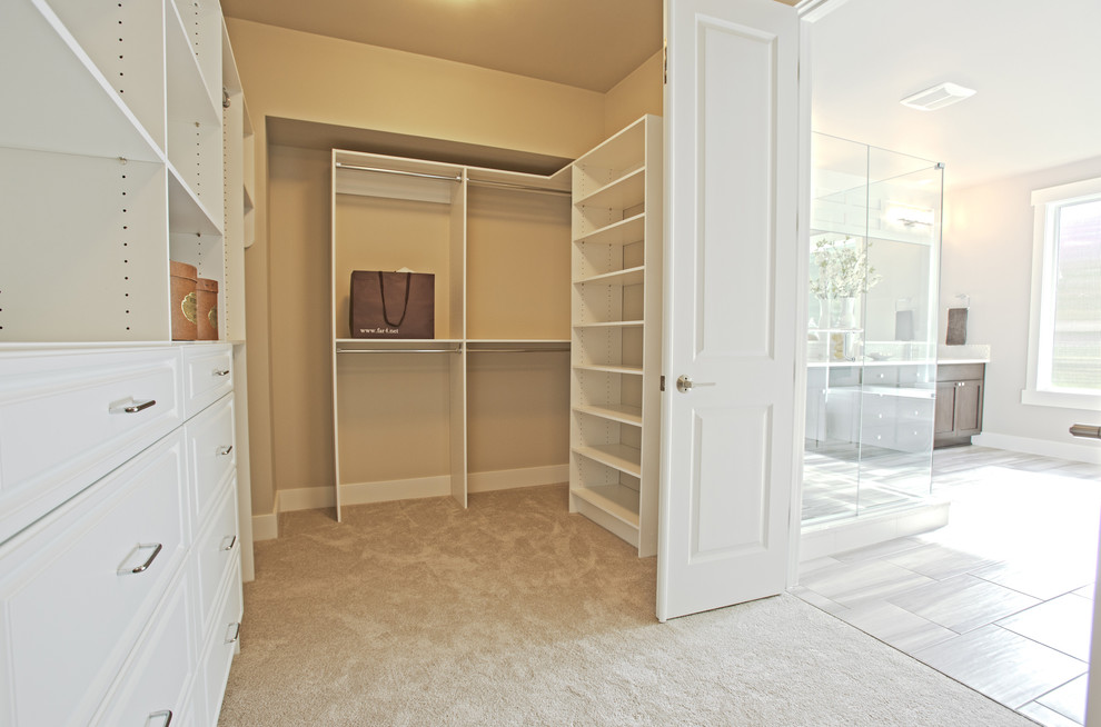 Ejemplo de armario vestidor unisex tradicional renovado grande con armarios con paneles empotrados, puertas de armario blancas y moqueta