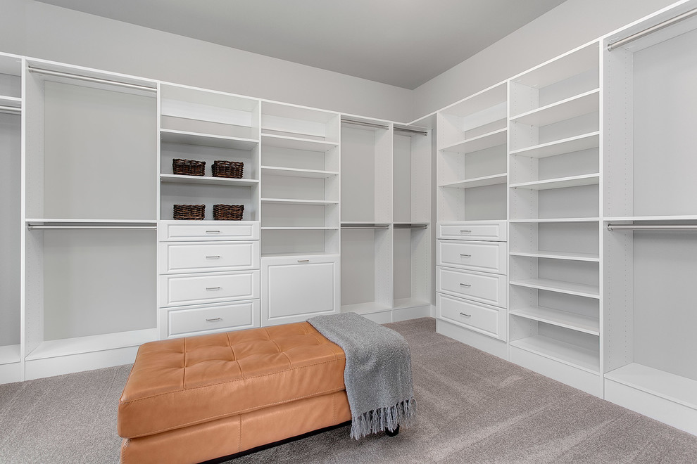 This is an example of a large traditional gender neutral walk-in wardrobe in Seattle with shaker cabinets, white cabinets and carpet.