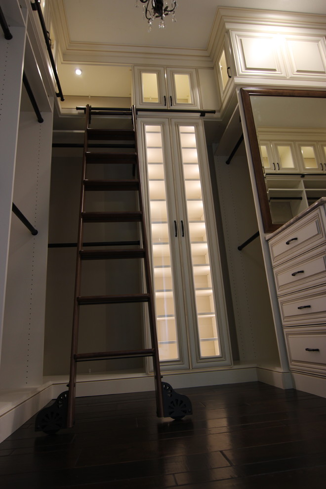 Exempel på ett stort klassiskt walk-in-closet, med luckor med upphöjd panel, beige skåp, mörkt trägolv och brunt golv